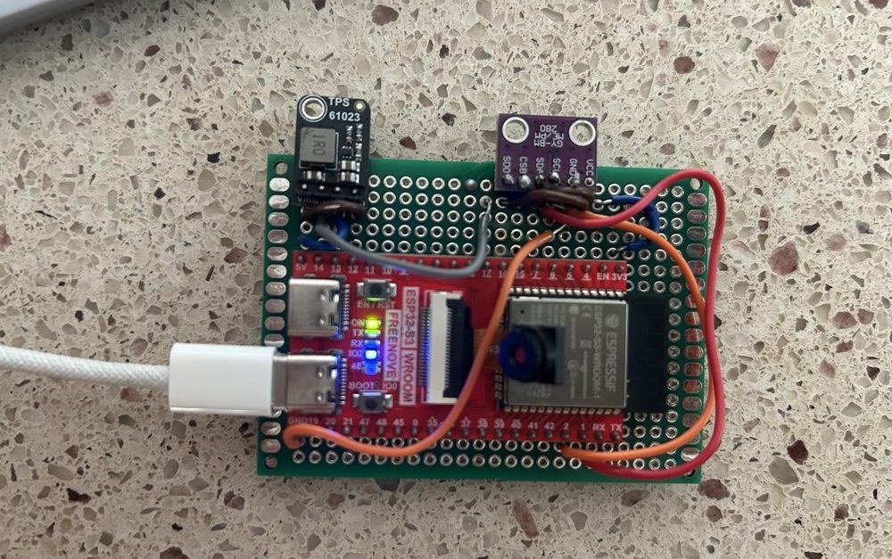The flight computer on soldered perfboard — an ESP32-S3 dev board, a purple BME280 breakout, and a TPS61023 boost converter, wired point to point.